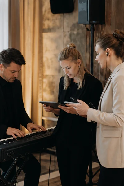 Musiker und Koordination besprechen einen diskreten Einsatz ohne sichtbare Marken oder Noten